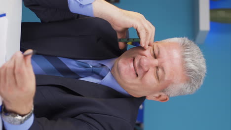 Vertical-video-of-Happy-businessman-using-phone-laughing.